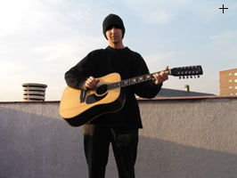 16.30h apoyada en un contenedor una ac&uacute;stica de 12 cuerdas. iba as� vestido y con un viol&iacute;n a la espalda